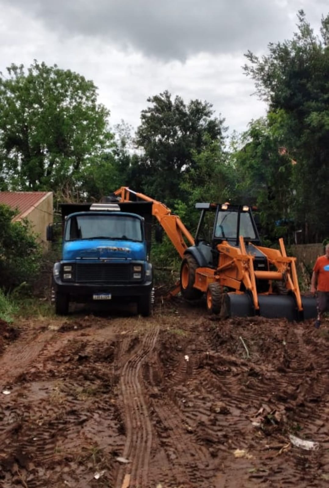 Caminhão caçamba e retroescavadeira em obra de terraplanagem